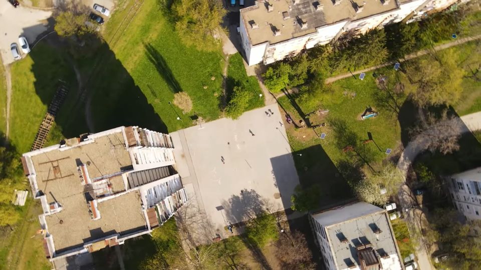 Vazdušni prikaz stambenog naselja sa zgradama, zelenim površinama i pešačkim stazama